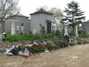 Aleea "tapetată" cu flori uscate, candele arse, bidoane etc.