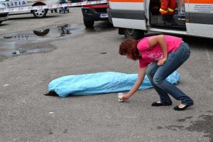 Lumânare aprinsă lângă trupul fără viaţă