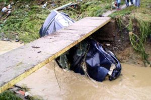 Luată de viitură, maşina a rămas sub podeţ