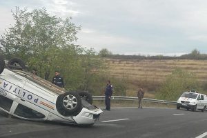 Maşină de poliţie dată cu roţile-n sus